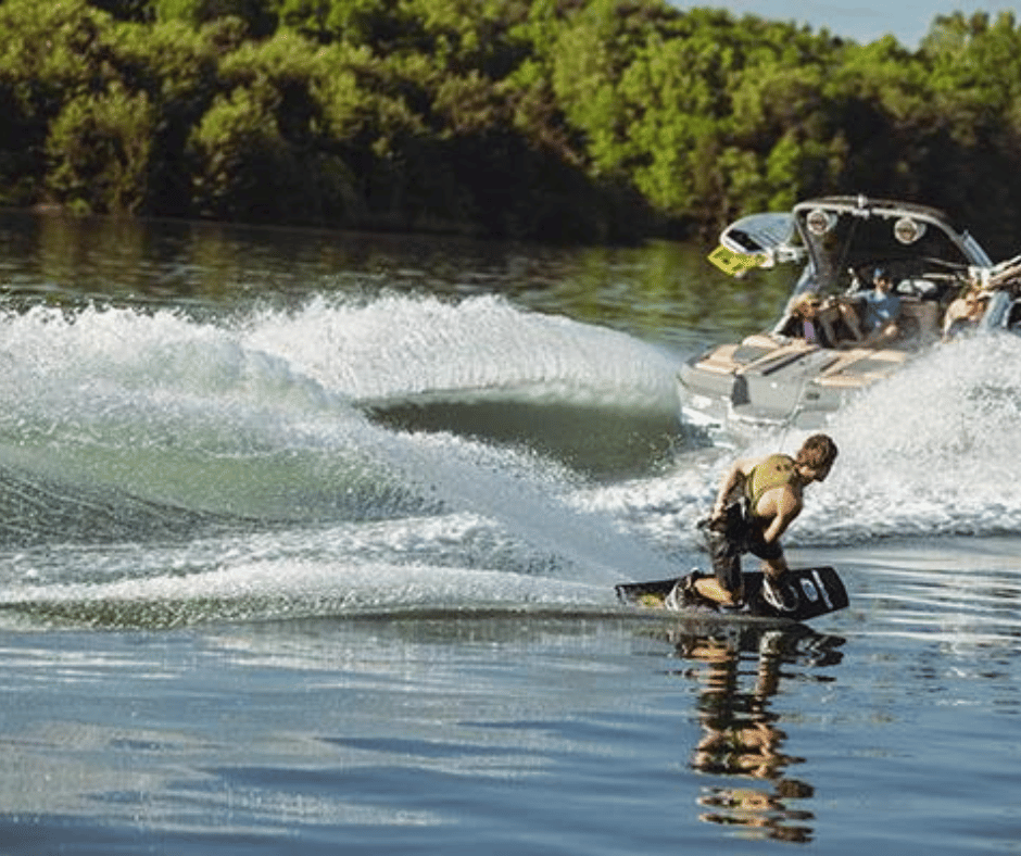 Mann auf Wakeboard hinter einem MasterCraft Boot